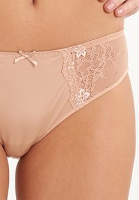 Beige hipsterondergoed voor vrouwen met een kanten paneel aan één kant, een delicate strikaccent en een gladde, elastische stof.