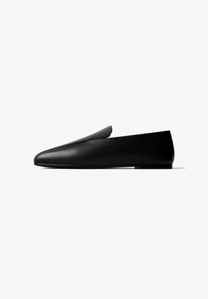 Schwarzer Lederloafer mit spitzer Kappe, niedrigem Absatz und Slip-On-Design, seitlich auf weißem Hintergrund dargestellt.