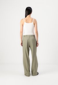Pantaloni leggeri, verde oliva, a gamba larga con una vestibilità comoda e cintura elastica; dotati di due tasche posteriori e una superficie liscia.