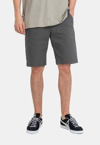 Gray cotton shorts with a straight fit, featuring side pockets. Paired with black suede sneakers and a light gray oversized t-shirt.