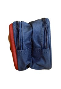 Kompaktowa niebieska saszetka z dwoma czarnymi zamkami błyskawicznymi i czerwoną boczną panelą, pokazana z boku.