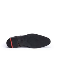 Zwarte schoenen zool met een gestructureerd oppervlak, voorzien van een gladde haksectie en een rode accentstreep nabij de achterkant. Inclusief logo-afdruk.