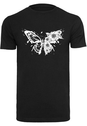 Sort bomulds t-shirt med et hvidt sommerfuglemønster sammenflettet med florale elementer, der viser en kompleks detaljering og splat-akkorder.
