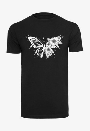 Mustaharja puuvillane T-särk, millel on valge liblika disain, mis on põimunud lilleelementidega, näidates keerukaid detaile ja pritsimisaktsente.