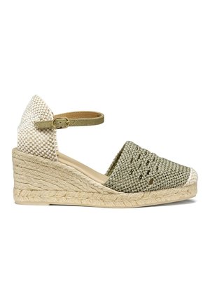 Sandale espadrille compensée avec bout vert tissé, talon à carreaux blancs, et bride de cheville beige avec boucle dorée sur semelle en jute.