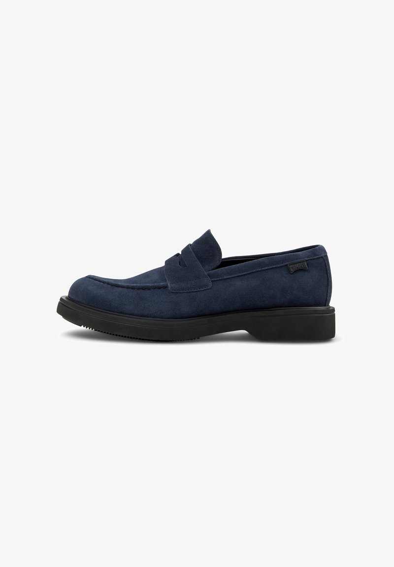 Mocasines de ante azul marino con un diseño sencillo, que presentan una textura suave, puntera redonda y una suela baja de goma negra.