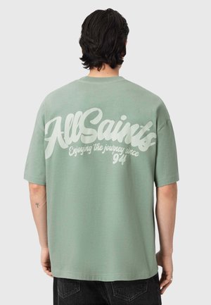 Mintgrünes T-Shirt in entspannter Passform, mit großem weißen Schriftzug "AllSaints" und "Enjoying the journey since '94" auf der Rückseite. Kurzärmlig.