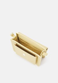 Borsa a tracolla gialla con texture, chiusura a pattina, hardware in argento, scomparti interni per carte e logo impresso. Presenta una tracolla removibile.