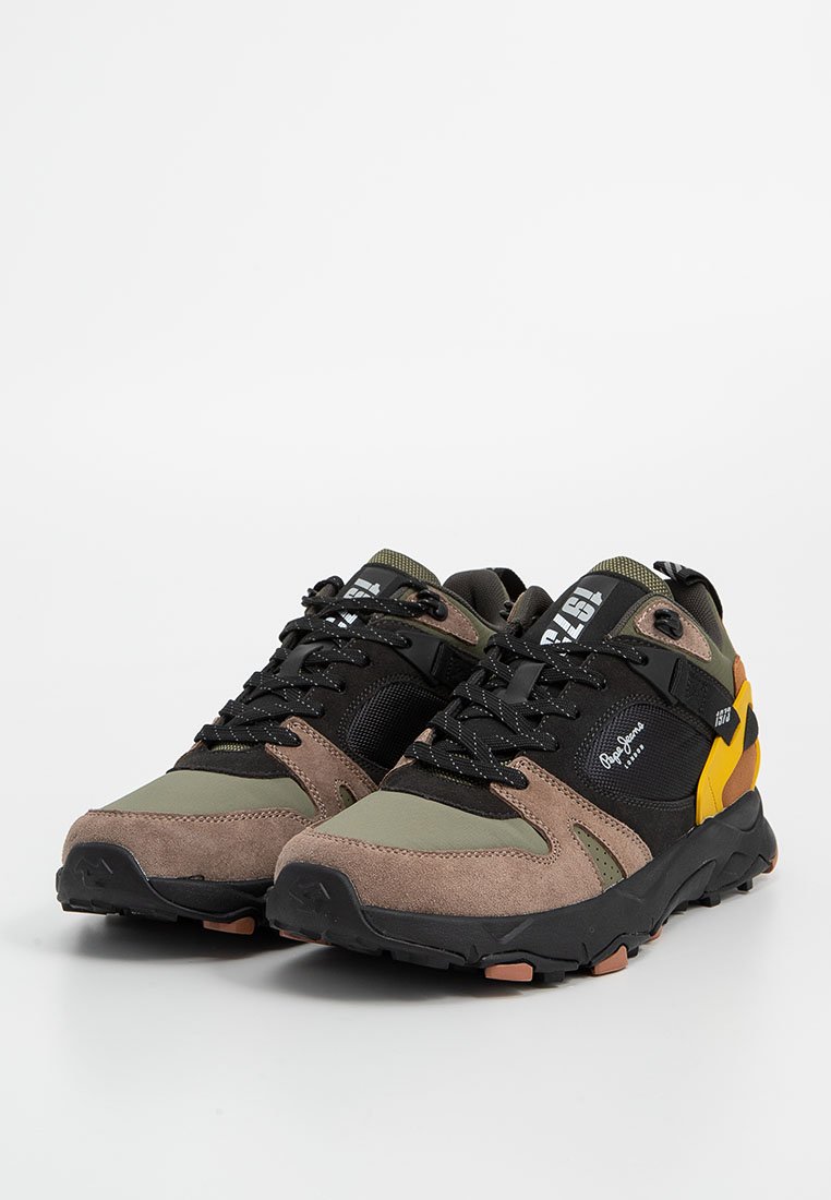 Sportieve sneakers met een mix van bruin, groen en zwart suede en mesh materialen. Voorzien van een gele accenten en een getextureerde rubbere zool.