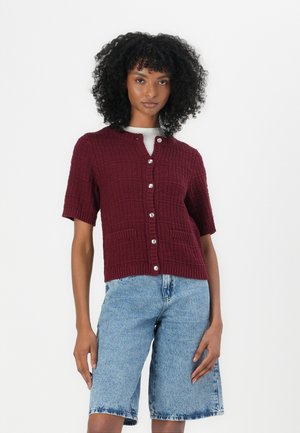 Cardigan en tricot bordeaux à manches courtes, col rond et fermeture à boutons sur le devant. Comprend deux poches avant et un motif texturé.