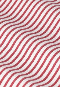 Tissu en coton avec des rayures ondulées rouges et blanches ; texture lisse ; motif uniforme ; aspect flexible et léger.