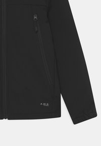 Black jacket made of smooth fabric, featuring a full zipper, side pocket with zipper, and a noticeable logo in the lower corner.