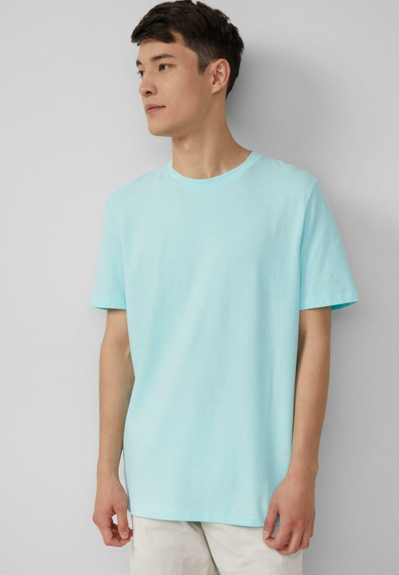 Lichtblauw T-shirt met korte mouwen, gemaakt van katoen, met een ronde hals en een losse pasvorm. Soepele textuur met een eenvoudig ontwerp.