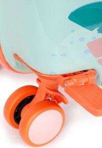 Close-up of orange dual wheels and a folding footrest attached to the bottom of a light blue and orange scooter or toy.