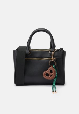 Schwarze Handtasche mit doppelten Tragegriffen, abnehmbarem Riemen und goldenen Reißverschlüssen. Verfügt über einen brezelartigen Schlüsselanhänger mit grünen Akzenten. Glatte Textur.