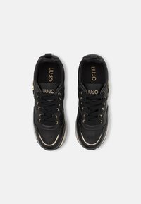 Sneakers neri realizzati in pelle e tessuto, con accenti dorati, lacci rotondi e una suola spessa bianca. Logo stampato sulla linguetta.