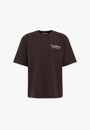 Pruun puuvillane T-särk lühikeste varrukatega, mille esiküljel on tekst "Uuri" beežiga ja "Sinu Horisonit" käekirjas. Üksik disain.