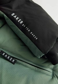 Schwarze und grüne Puffjacke mit dem Markenlabel "BAKER" und "by TED BAKER", ausgestattet mit einer eleganten, gesteppten Textur und Reißverschlussdetails.