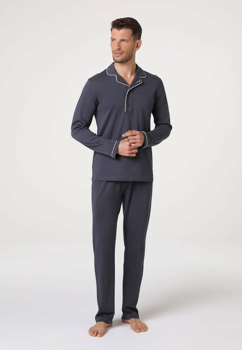 Completo pigiama da uomo in grigio scuro. La maglia a maniche lunghe presenta un colletto con piping bianco e una chiusura a bottoni. I pantaloni sono dritti e abbinati.