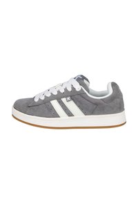 Zapatilla de ante gris con rayas blancas, cordones planos blancos y suela de goma. Presenta perforaciones para ventilación y un detalle del logo.