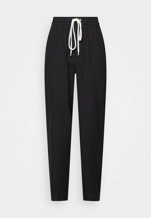 Czarne dresy z troczkiem w pasie, tapered leg design oraz miękką teksturą materiału. Posiadają biały troczek dla kontrastu.