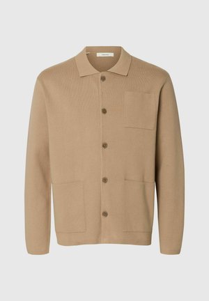 Gilet en tricot beige avec un col, cinq boutons et deux poches avant. Dispose d'une poche sur la poitrine gauche et d'une texture douce.