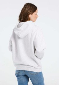 Felpa con cappuccio grigia chiara in pile, dotata di tasca a marsupio, polsini a costine e un design semplice senza loghi visibili.