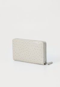 A rectangular wallet in light beige leather, featuring a dotted texture, silver zipper, and a sleek design.