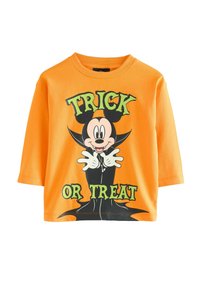 Oranžové bavlnené tričko s kreslenou postavičkou v smokingu, s textom "TRICK OR TREAT" v zelenej farbe, čiernymi akcentmi a klasickým okrúhlym výstrihom.