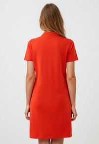Rood katoenen jurk met korte mouwen, een klassieke kraag en een rechte snit. Gladde textuur, tot halverwege de dijen in lengte.
