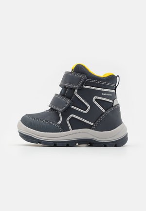 Bota impermeable infantil en azul marino y gris con forro interior amarillo y dos correas de Velcro, diseñada para uso exterior.