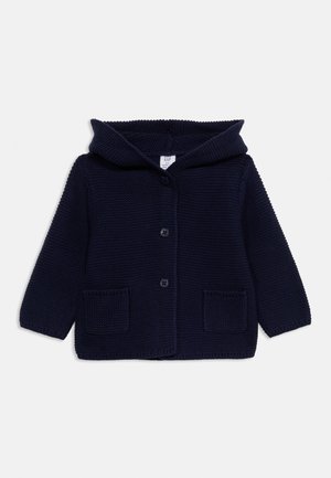 Tmavomodrý pletený detský sveter s kapucňou, dlhými rukávmi, dvoma prednými vreckami a tromi čiernymi gombíkmi v strede.