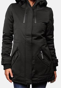 Parka noir isolée avec capuche, poches latérales zippées et manches côtelées. Texture lisse avec cordons de serrage réglables.