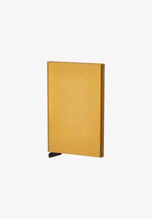 Gelbes metallisches rechteckiges Notizbuch mit glatter Textur und einem schwarzen Eckenakzent für einfachen Zugang. Minimale Markenkennzeichnung an der Seite.
