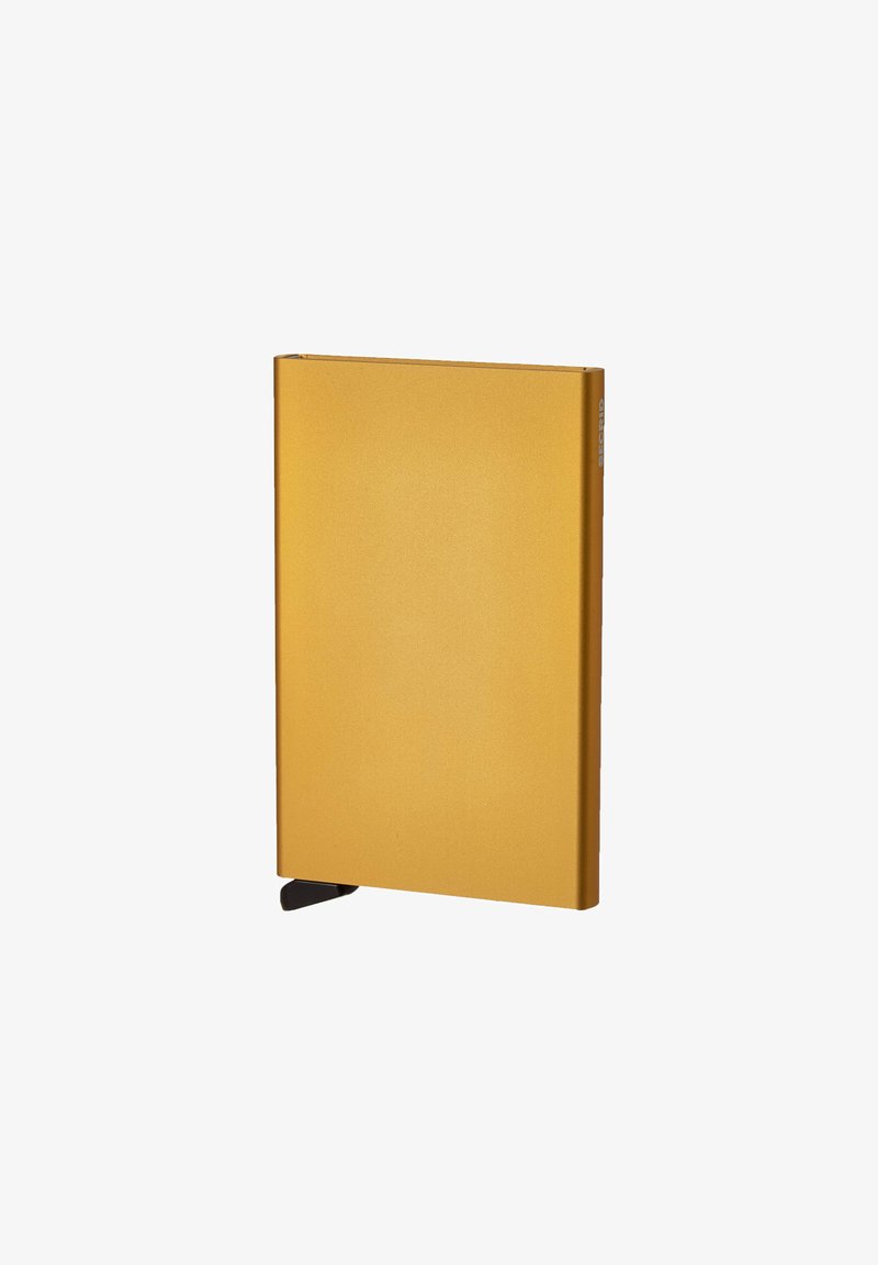 Gelbes metallisches rechteckiges Notizbuch mit glatter Textur und einem schwarzen Eckenakzent für einfachen Zugang. Minimale Markenkennzeichnung an der Seite.