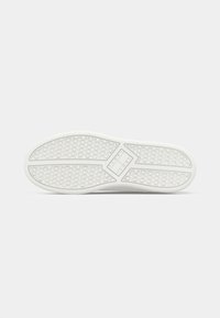 Talpa de sneaker albă cu un model texturat în formă de fagure. Prezintă un design în formă de diamant în centru și o margine exterioară netedă.