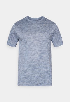 Modra kratka majica s kratkimi rokavi iz teksturiranega blaga z rahlim vzorcem. Ima majhen črn Nikeov logotip na zgornjem levem delu.