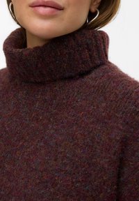Pull à col roulé bourgogne en tricot texturé, avec un col côtelé et de subtils fils multicolores intégrés dans le tissu.