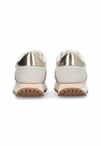 Baskets blanches avec des accents métalliques dorés au talon, semelle extérieure beige texturée et matière supérieure lisse. Détails réfléchissants à l'arrière.