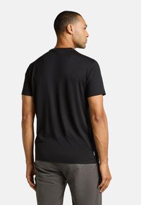 Sort kortærmet t-shirt med rund hals, lavet af et glat, letvægtsstof. Har et lille mærke på den nedre side.