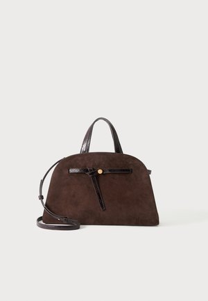 Sac à main en daim brun foncé avec une forme arrondie structurée, des poignées courtes, une longue bandoulière et une sangle en cuir noire décorative avec bouton doré.