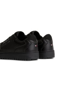 Mustat nahkakengät verkkomaisilla yksityiskohdilla, pyöristetty kärki, teksturoidut kumipohjat ja minimaalinen brändäys, jossa on pieni logo kantapäässä.