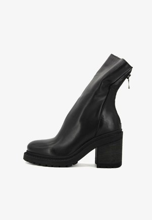 Stivale alla caviglia in pelle nera con finitura liscia, tacco spesso e testurizzato, chiusura con zip laterale e design minimale, dotato di punta arrotondata.