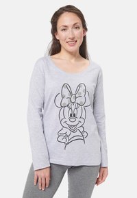 T-shirt a maniche lunghe grigio chiaro in cotone con un grafico a contorno nero della faccia di un personaggio dei cartoni animati e un fiocco sulla parte anteriore.