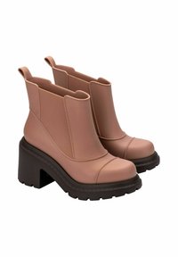 Różowe gumowe botki za kostkę na słupku, z teksturowanym panelem bocznym, okrągłym noskiem i uchwytami do łatwego zakładania.