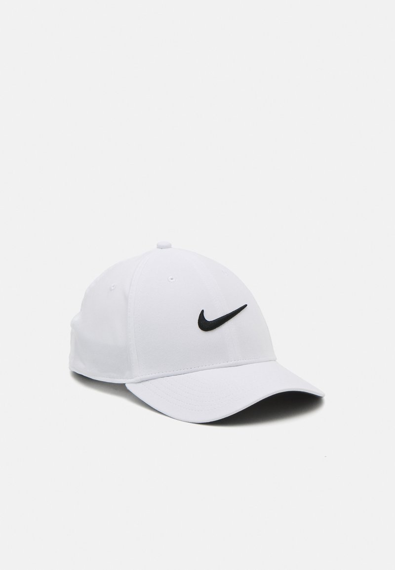 Valge puuvillane pesapallimüts, mille esiosas on must tikandiga Nike'i logo, kumer äär ja kuuepaneeline struktuur.