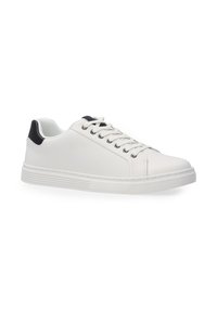 Białe sneakersy z teksturowanym wykończeniem, czarnym akcentem na pięcie i tradycyjnym zapięciem na sznurówki. Gruba gumowa podeszwa dla wsparcia.