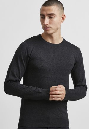 Mørkegrå strikkegenser med rund hals, lange ermer og ribbestrikkede mansjetter og kant. Stoffet virker mykt og strukturert.