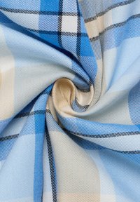 Weicher Stoff mit einem karierten Muster in Blau, Beige, Weiß und Schwarz, zu einer zentralen Spiralform gewunden.