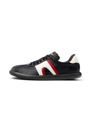 Black leather sneaker with white and red accents, rounded toe, textured upper, flat black sole, and lace-up design.